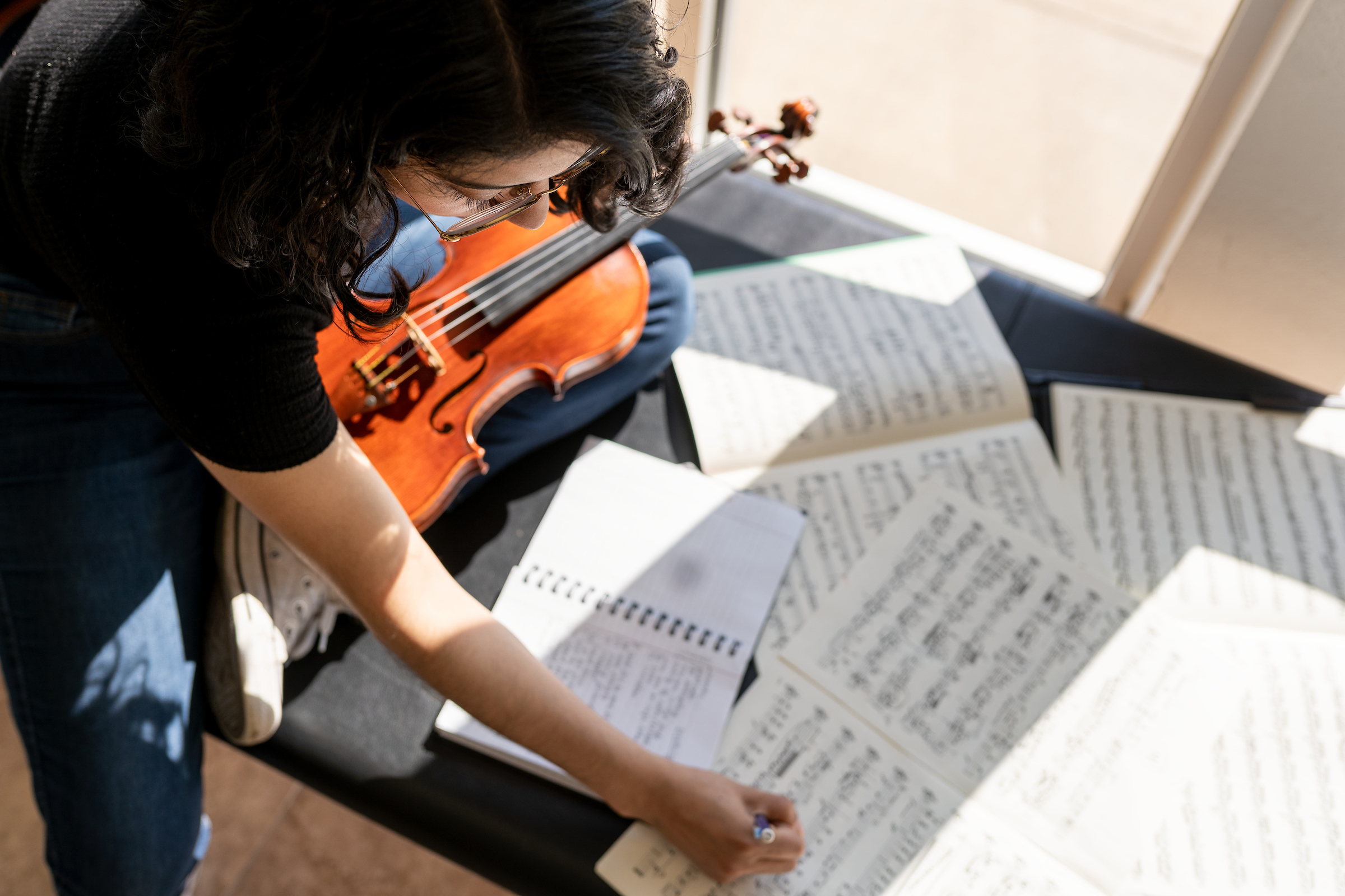 Student profile of Leticia Gomez, Music Education major, with her violin in Bengtson Auditorium in Russell Hall.
